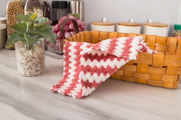 A close-up of various colorful reusable cleaning cloths neatly folded in a basket, placed on a countertop next to a sink.