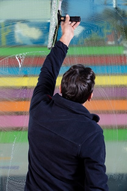 A person holding a thermal imaging camera, pointing it at an exterior wall of a house. The camera screen displays a colorful heat map, showing areas of heat loss around windows and door frames. The image highlights the use of technology in identifying energy inefficiencies.