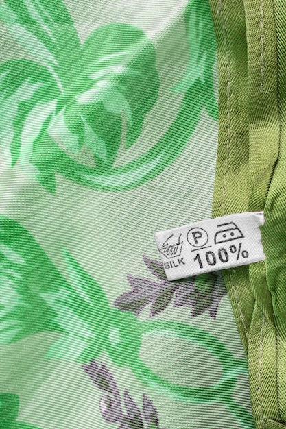 A detail shot of a garment label showing a sustainable certification logo, such as GOTS or Fair Trade. The focus is on the symbol itself and its significance.
