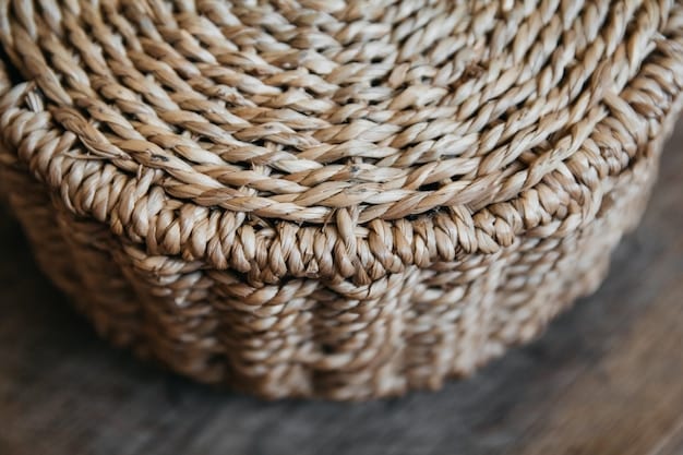 A close-up shot of a woven basket made from natural fibers, displaying its intricate texture and craftsmanship. The basket contains a variety of organic cotton towels and toiletries, showcasing sustainable storage solutions.