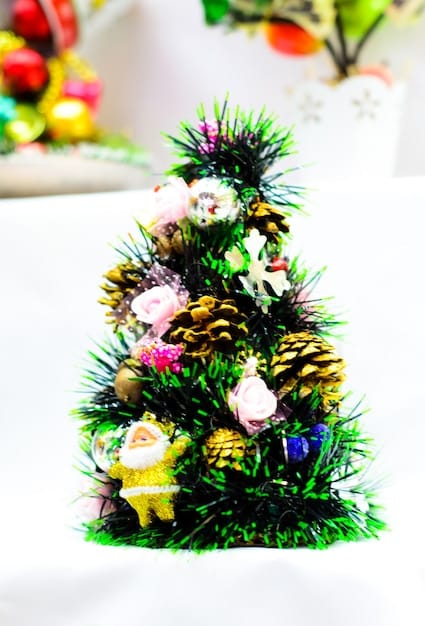 A brightly decorated Christmas tree made of natural materials, such as wooden ornaments, pine cones, and paper stars. The tree is lit with energy-efficient LED lights.