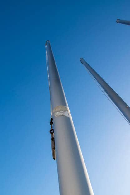 A detailed shot of a wind turbine blade being manufactured in a factory, with workers in hard hats overseeing the process. The image highlights the importance of domestic manufacturing in the renewable energy sector.