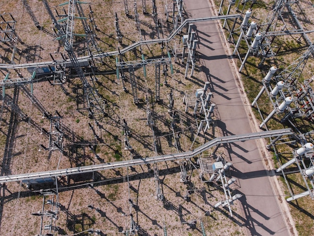 A close-up aerial shot of a substation with newly installed high-voltage transmission lines connected to a wind farm in the distance, illustrating grid modernization and renewable energy integration.