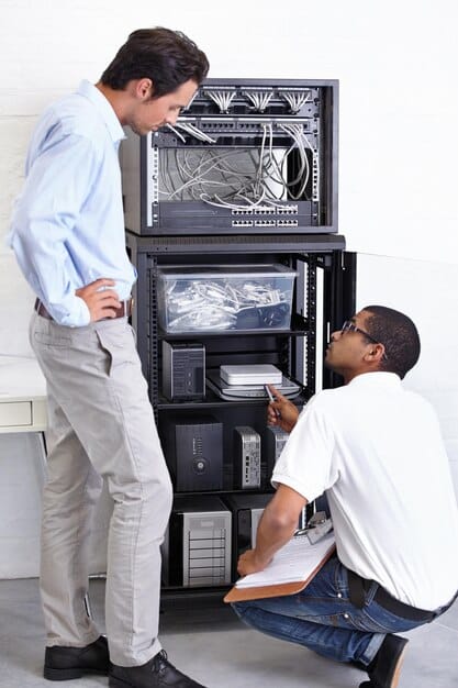 A technician inspecting a home energy storage battery system, using diagnostic tools. The focus is on the technician's expertise and the advanced technology used to monitor and maintain the battery's health, suggesting professional maintenance practices.