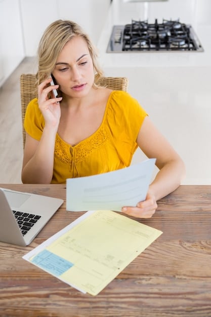 A person filling out IRS Form 5695 on a desk with a calculator, receipts, and other tax-related documents.