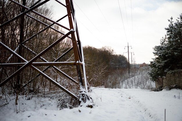A photograph illustrating the damage to a transmission tower caused by a severe ice storm. The tower is heavily coated in ice, with some sections collapsed or leaning precariously. The image emphasizes the vulnerability of energy infrastructure in northern states to climate change-related weather events.